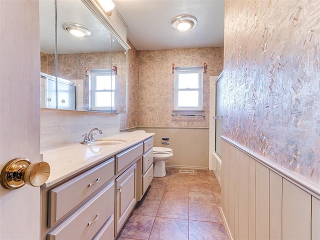 full bathroom with toilet, vanity, tile patterned flooring, wooden walls, and shower / bath combination with glass door