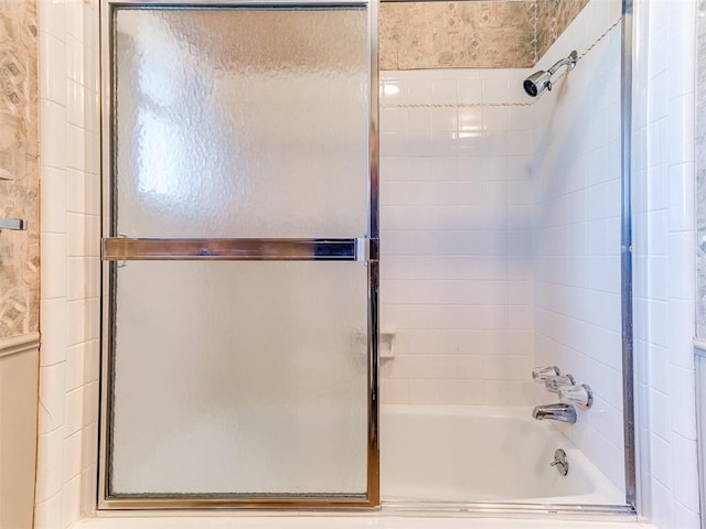 bathroom with combined bath / shower with glass door