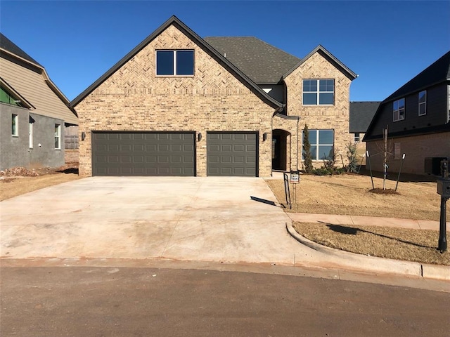 view of front of property featuring a garage and central AC