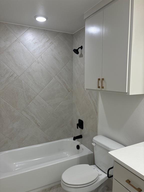 full bathroom with tiled shower / bath, vanity, and toilet