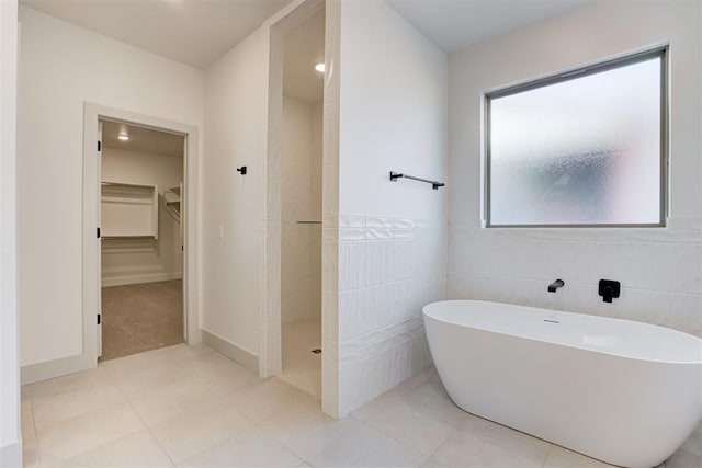 bathroom featuring independent shower and bath and tile walls