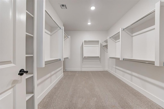 walk in closet featuring light colored carpet