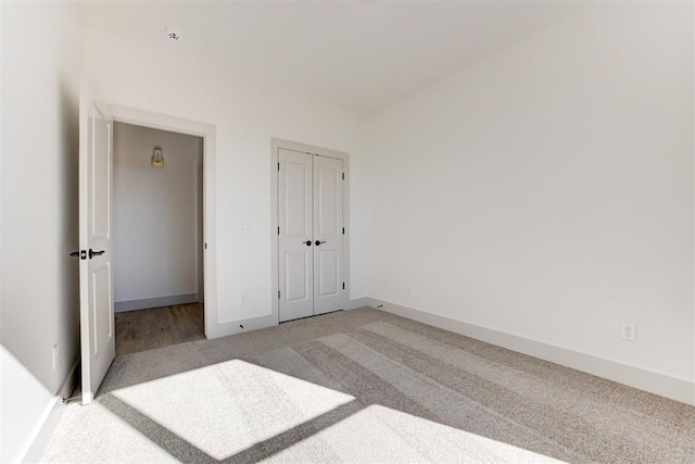 unfurnished bedroom with a closet and light carpet