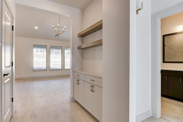 kitchen with a notable chandelier, decorative light fixtures, light hardwood / wood-style floors, and white cabinets