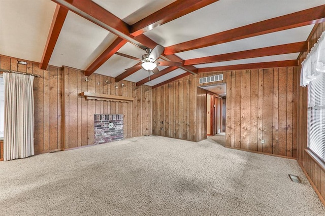 unfurnished living room with lofted ceiling with beams, carpet floors, wooden walls, and ceiling fan