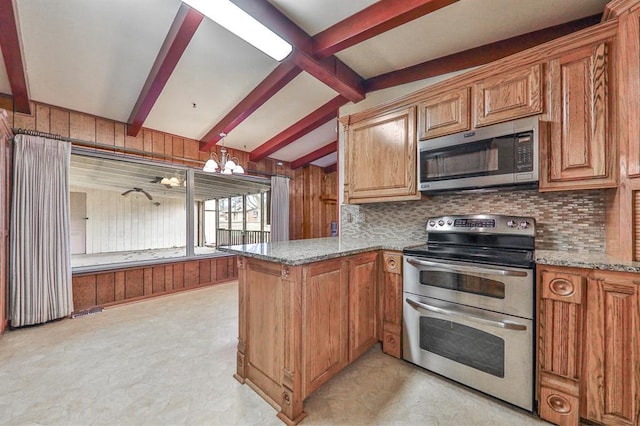 kitchen featuring lofted ceiling with beams, appliances with stainless steel finishes, kitchen peninsula, a notable chandelier, and light stone countertops