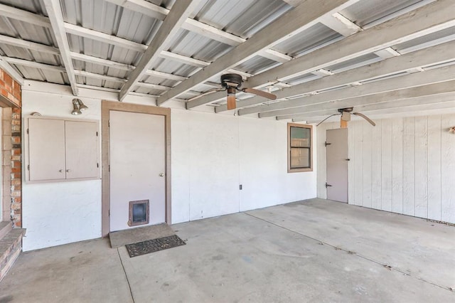 garage with ceiling fan and wood walls