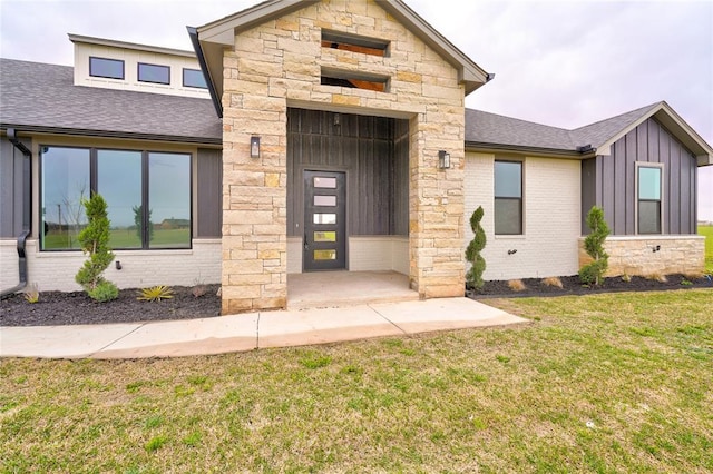 property entrance featuring a patio and a lawn