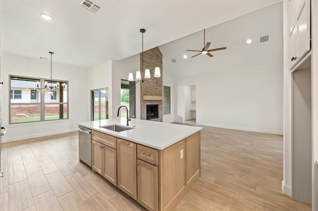 kitchen featuring visible vents, dishwasher, a sink, ceiling fan with notable chandelier, and open floor plan