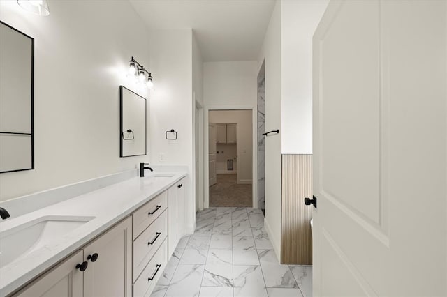 bathroom featuring a sink, baseboards, double vanity, and marble finish floor