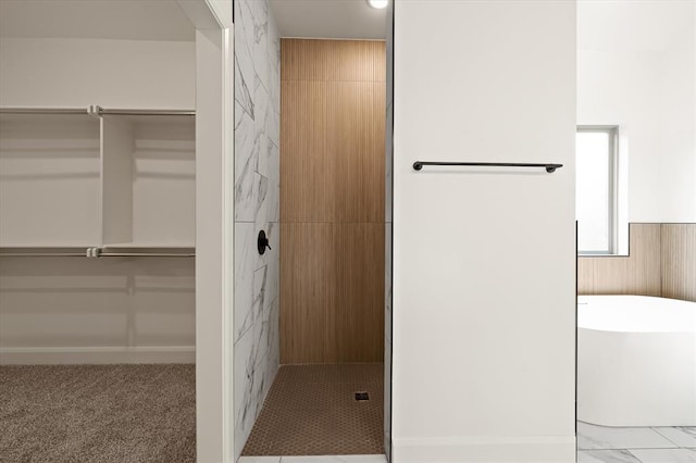 full bath with a walk in closet, tiled shower, and a soaking tub