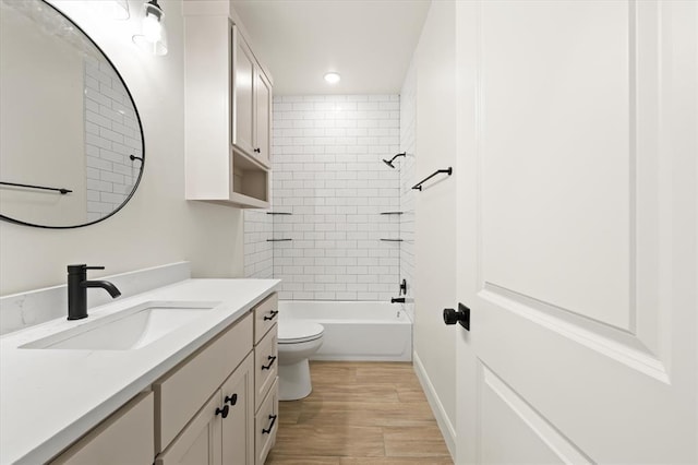 bathroom with wood finished floors, vanity, toilet, shower / bathtub combination, and recessed lighting