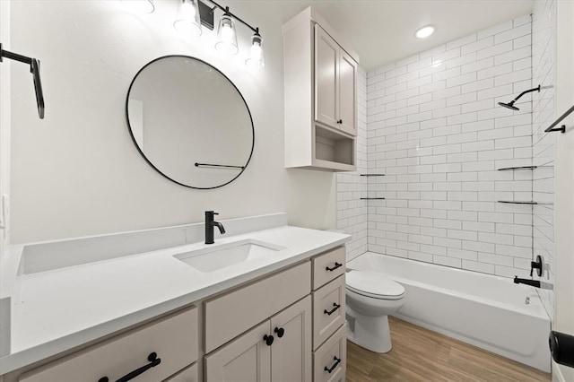 bathroom featuring wood finished floors, vanity, toilet, recessed lighting, and tub / shower combination