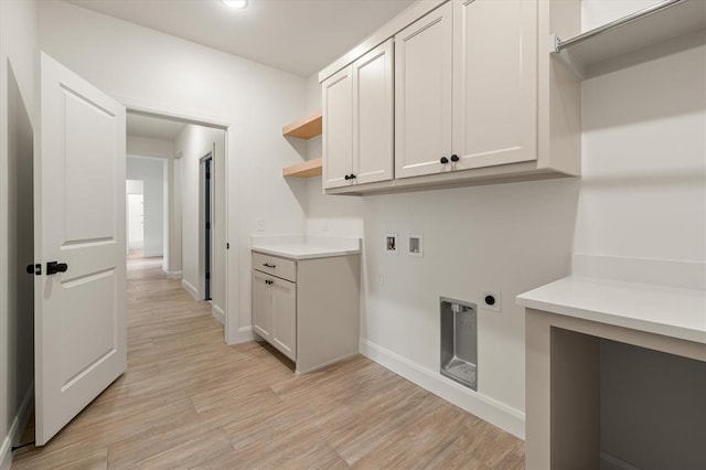 laundry area with baseboards, hookup for a washing machine, light wood-type flooring, cabinet space, and hookup for an electric dryer