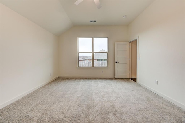 spare room featuring ceiling fan, light colored carpet, and vaulted ceiling