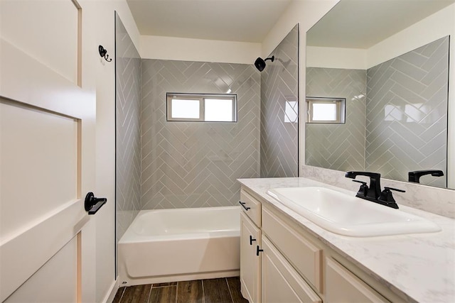 bathroom featuring tiled shower / bath combo, vanity, and hardwood / wood-style floors