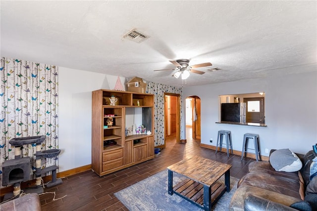 living room featuring a textured ceiling and ceiling fan