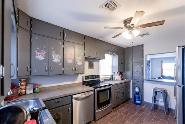 kitchen with ceiling fan, stainless steel appliances, sink, and gray cabinets