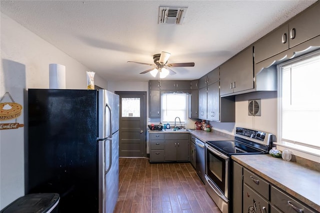 kitchen with ceiling fan, sink, a textured ceiling, and appliances with stainless steel finishes