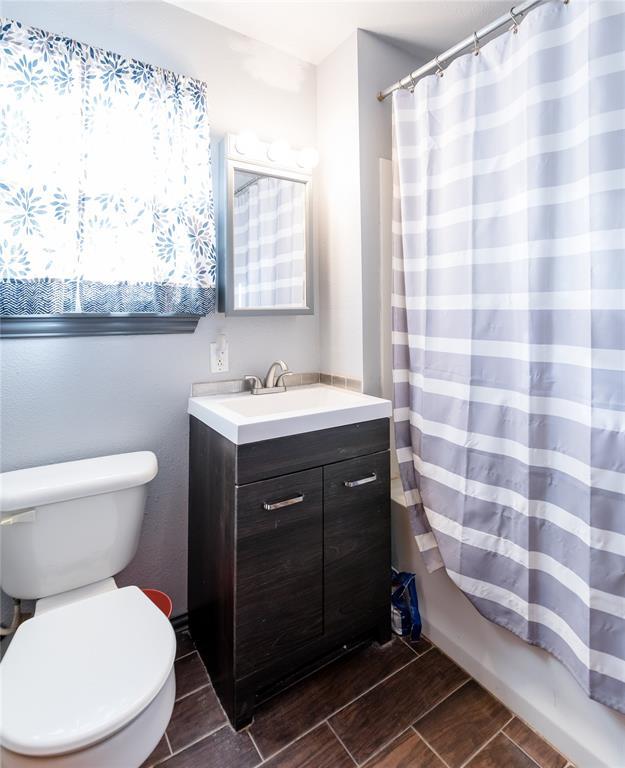 full bathroom featuring toilet, vanity, and shower / bathtub combination with curtain