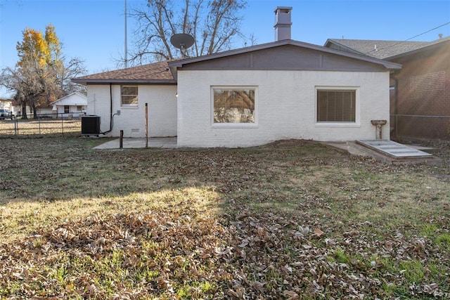 rear view of house featuring a patio, fence, a yard, central air condition unit, and brick siding