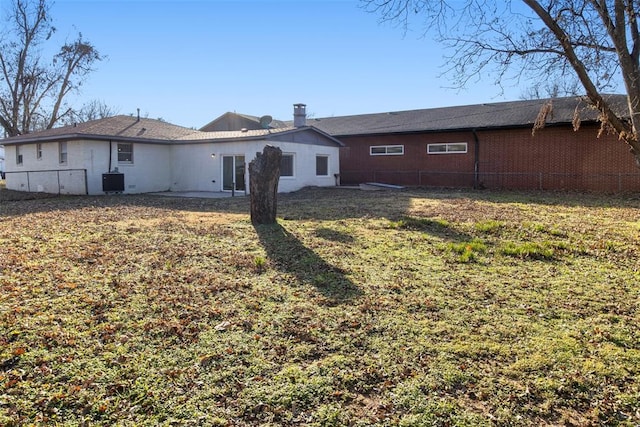 rear view of property with a lawn, central AC unit, a fenced backyard, and a patio area