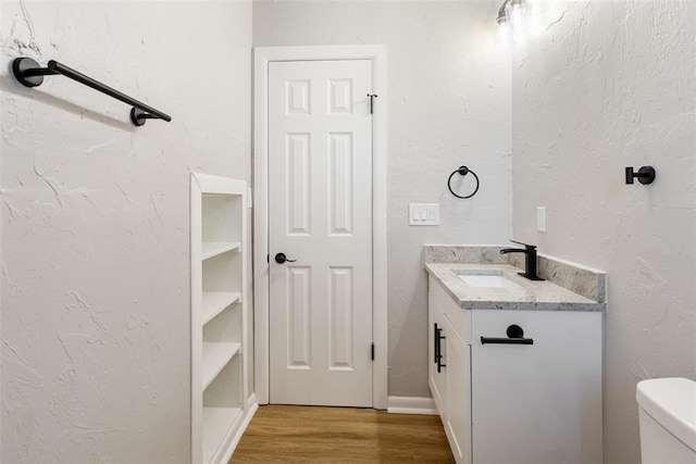 bathroom featuring wood finished floors and a textured wall