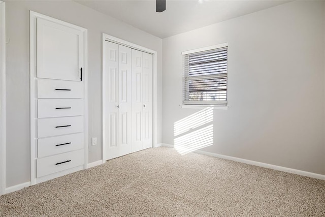 unfurnished bedroom featuring a closet, baseboards, carpet, and a ceiling fan