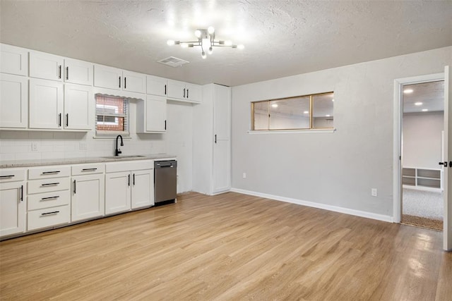 kitchen featuring visible vents, light wood-style flooring, a sink, light countertops, and dishwasher