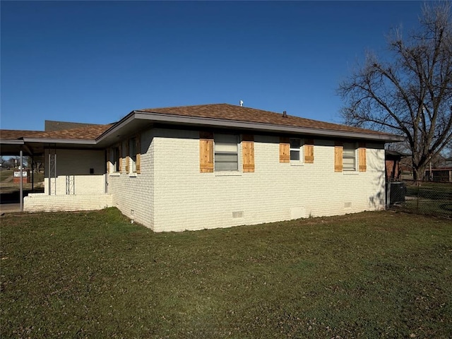 view of home's exterior with crawl space, brick siding, a yard, and fence