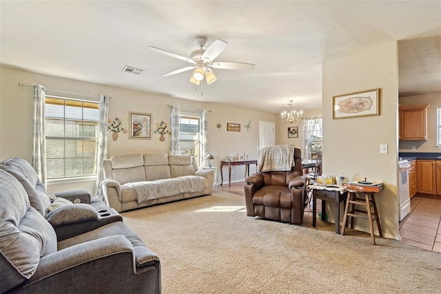 living room featuring ceiling fan with notable chandelier and light colored carpet