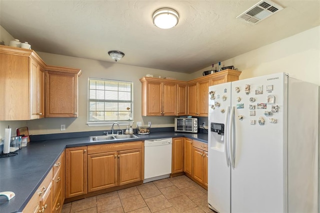 kitchen featuring sink, white appliances, and light tile patterned floors