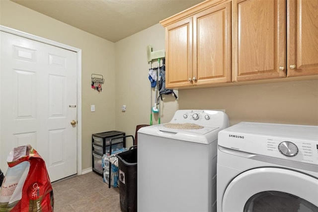 clothes washing area with cabinets and washer and clothes dryer