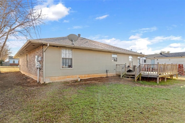 rear view of property with a deck and a lawn