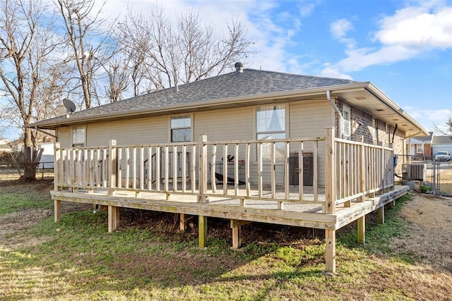 rear view of house featuring a deck, a lawn, and central air condition unit