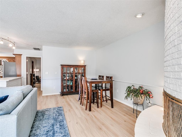 dining area featuring light hardwood / wood-style floors and a textured ceiling