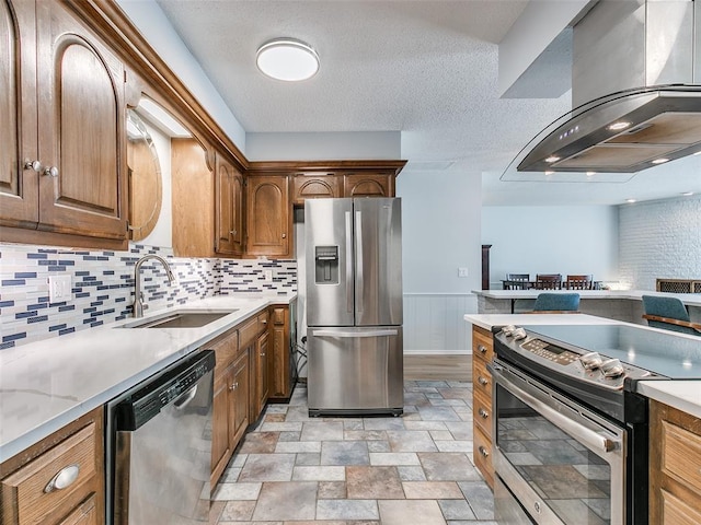 kitchen with sink, island range hood, a textured ceiling, stainless steel appliances, and backsplash