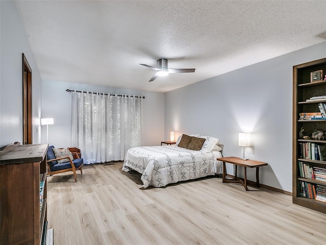 bedroom featuring light wood-type flooring, a textured ceiling, and ceiling fan