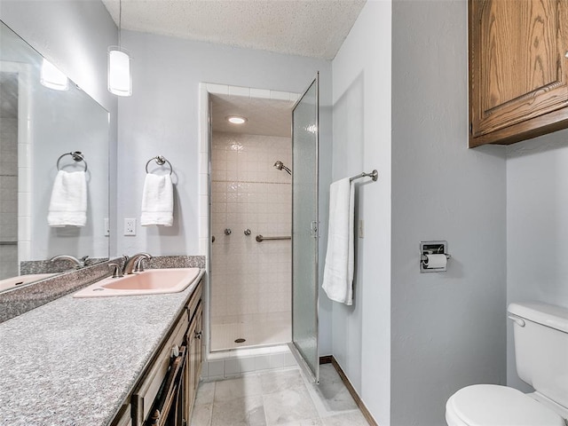 bathroom featuring vanity, tiled shower, a textured ceiling, and toilet