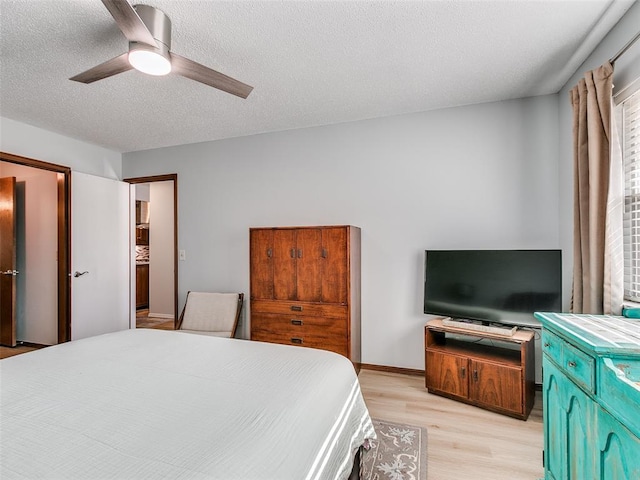 bedroom with light wood-type flooring, a textured ceiling, and ceiling fan