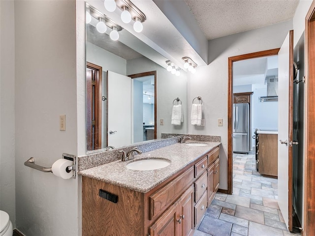 bathroom featuring vanity, toilet, and a textured ceiling