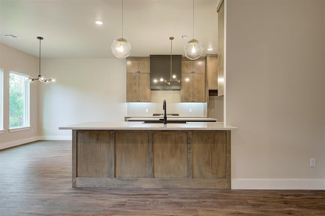 kitchen featuring sink, decorative light fixtures, backsplash, and hardwood / wood-style flooring
