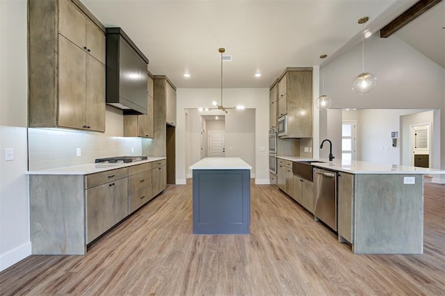 kitchen featuring light hardwood / wood-style floors, sink, hanging light fixtures, and appliances with stainless steel finishes