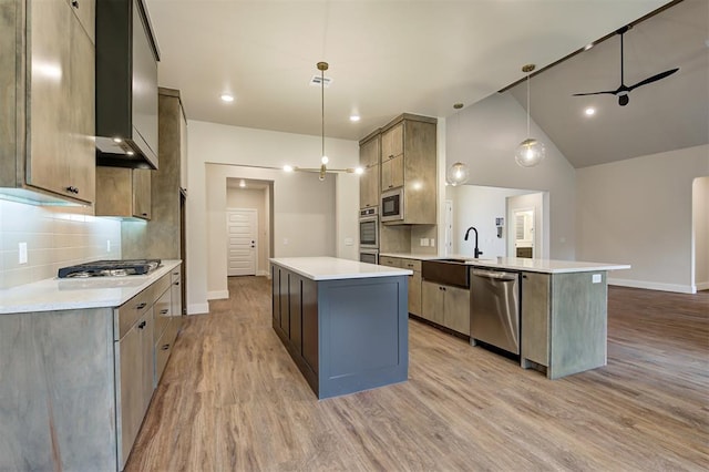 kitchen with decorative light fixtures, sink, appliances with stainless steel finishes, and kitchen peninsula