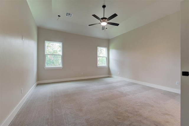 empty room featuring ceiling fan, light colored carpet, and lofted ceiling