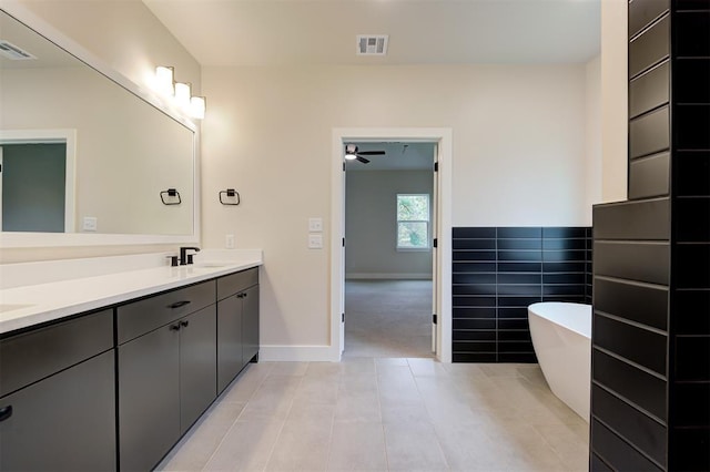 bathroom featuring a bathtub, tile walls, and vanity
