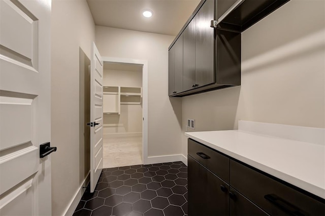 clothes washing area featuring washer hookup, dark tile patterned floors, and cabinets