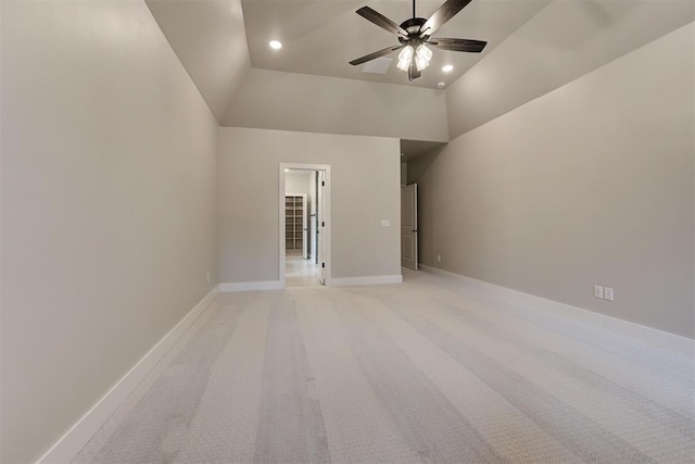 empty room featuring lofted ceiling, light carpet, and ceiling fan