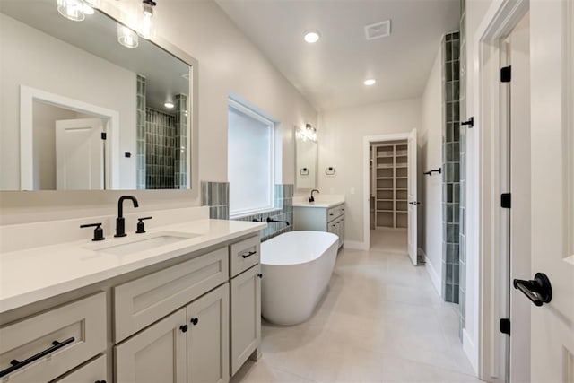 bathroom with tile patterned flooring, vanity, and a tub