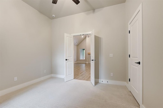 unfurnished bedroom with vaulted ceiling, light colored carpet, and ceiling fan